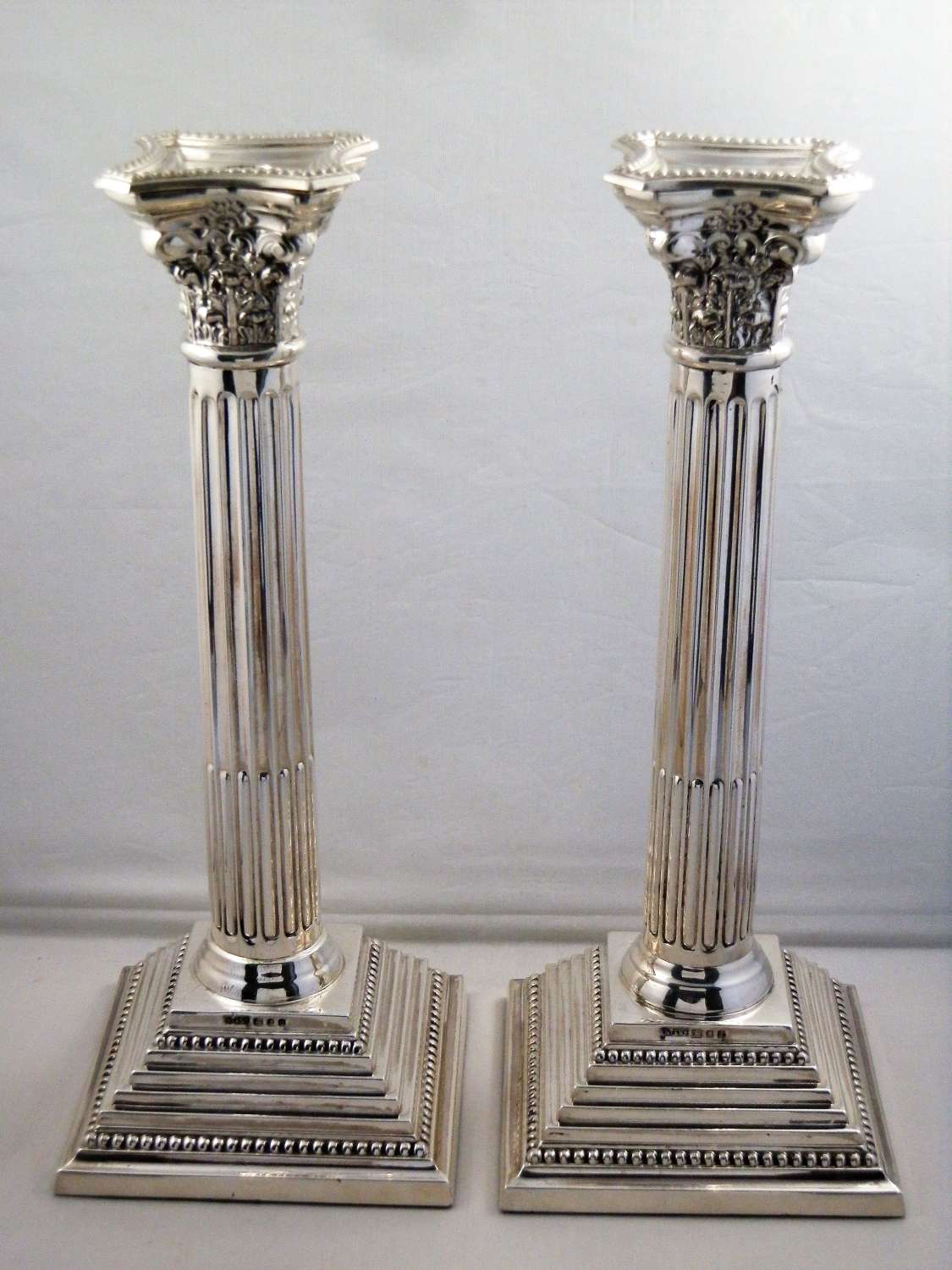 Pair of silver corinthian candle sticks, London 1960